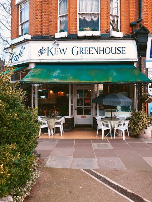 An aerial view of a small shopping street featuring a white, semi-detached building with a black awning labeled 'Thames Food & Wine' and a green awning with the Gardeners Harrow on the Hill logo. The 